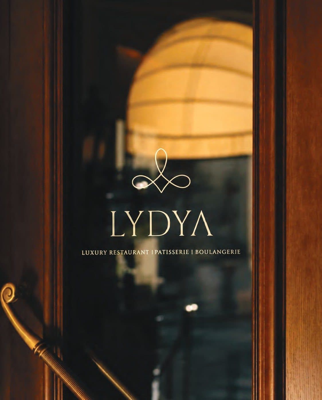 LYDYA's brass entrance signage at dusk